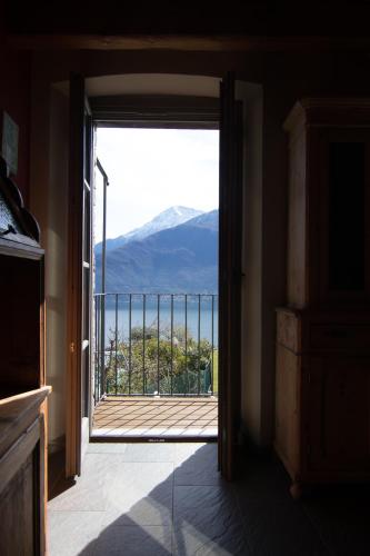 an open door to a balcony with a view of the mountains at Agriturismo Treterre in Pianello Del Lario