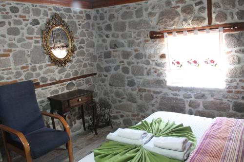 a bedroom with a bed and a chair and a mirror at TAŞKONAK in Bergama
