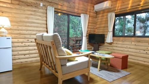 a living room with a table and a chair and a desk at るり渓 フォレストヴィラ in Nantan city