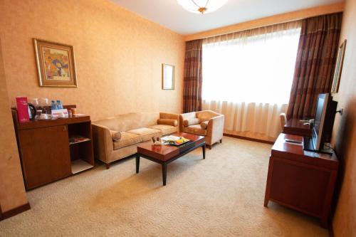a living room with a couch and a table at Ramada Plaza by Wyndham Gence in Ganja