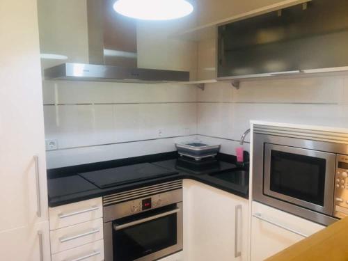 a kitchen with a stove and a microwave at Apartament Vall d'Àger II in Ager