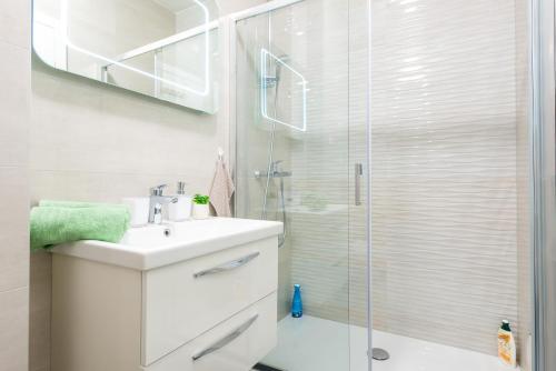 uma casa de banho com um lavatório e um chuveiro em Apartment MaLa em Dubrovnik