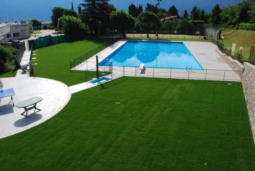 an overhead view of a large swimming pool with green grass at Appartamento Bijoux - Rebomaholidays in Tignale