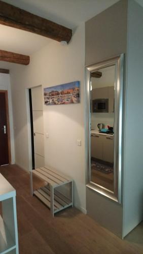 une chambre avec un banc et un miroir dans l'établissement Sam Le Lezard Sarl, à Nice