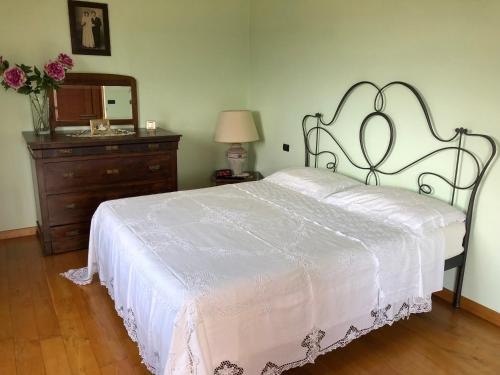 a bedroom with a white bed with a dresser and a mirror at The Forest House in Isernia
