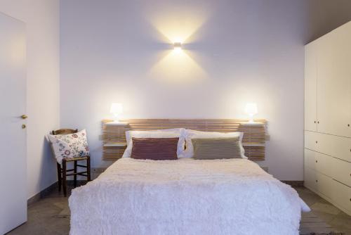 a bedroom with a large bed with two lights on the wall at Moma1 - by MyHomeInComo in Como