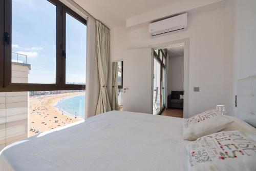 ラスパルマス・デ・グランカナリアにあるLovely balcony sea views By CanariasGetawayのビーチの景色を望むベッドルーム1室(ベッド1台付)が備わります。