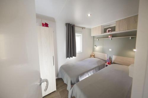 ein kleines Zimmer mit 2 Betten und einem Fenster in der Unterkunft Camping Victoria in Canet de Mar