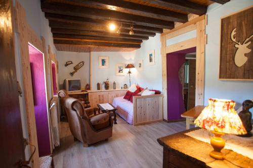 a living room with a bed and a couch at CASA SENERA in Santa Cruz de la Serós