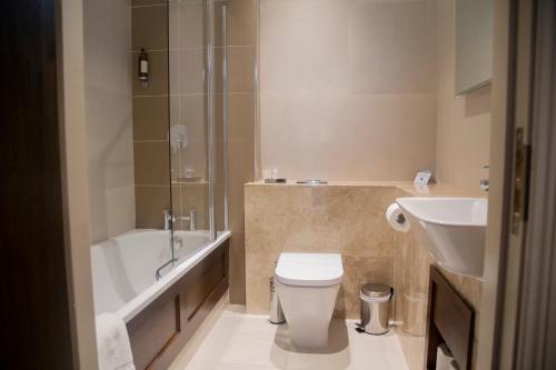 y baño con bañera, aseo y lavamanos. en Rooms At Rue, en Omagh