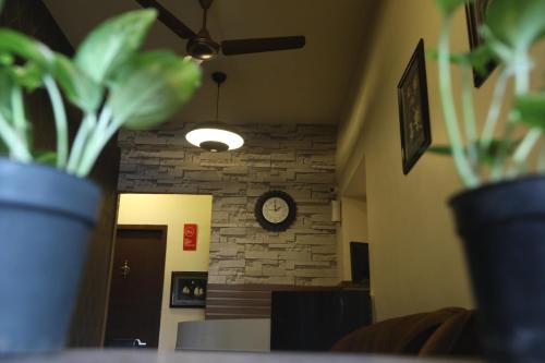 a room with a clock on a brick wall at Nestlay Rooms Ambattur in Chennai