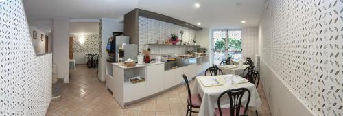 a kitchen with a counter and a table in a room at Hotel Letizia in Rimini