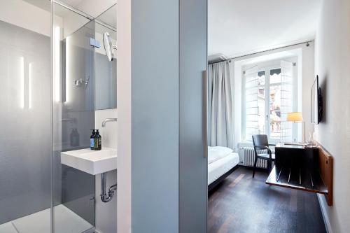 La salle de bains est pourvue d'un lavabo et d'un miroir. dans l'établissement Krafft Basel, à Bâle