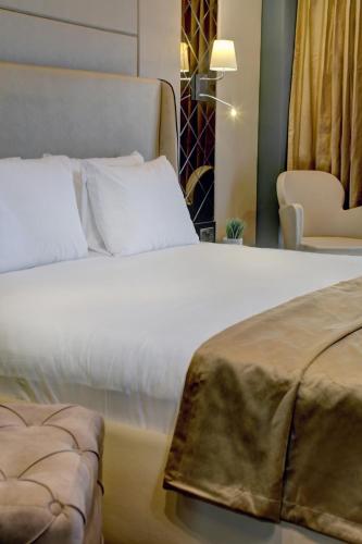 a bedroom with a large white bed and a chair at Putney Hotel in London