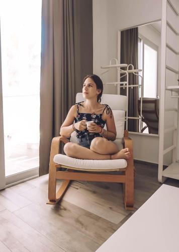 a woman sitting on a chair in a room at Camarò Favignana in Favignana