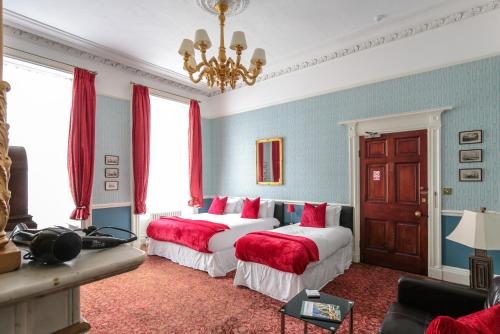 two beds in a room with red and blue walls at City Studios - Rodney Street in Liverpool