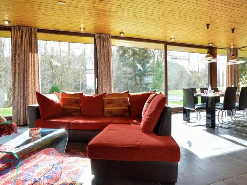 - un salon avec un canapé rouge et une table dans l'établissement Luxury villa with swimming pool mid may till mid sept near to F1 circuit, à Stavelot