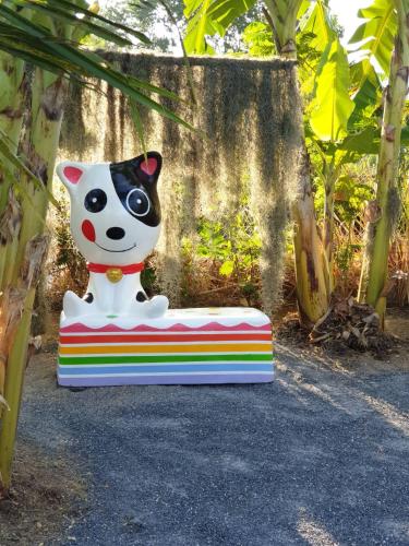 a statue of a dog sitting on a bench at บ้านสวนนิสา in Sattahip