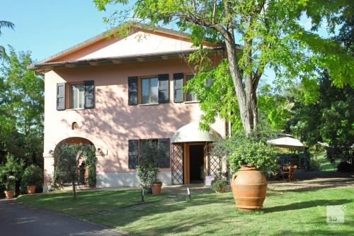 a house with a tree in the front yard at Locanda Dei Cinque Cerri in Sasso Marconi