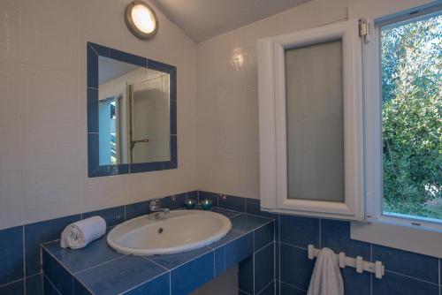 ヴィッラシミーウスにあるSul Mare Sardegna Villa Eulimeneのバスルーム(洗面台、鏡、窓付)