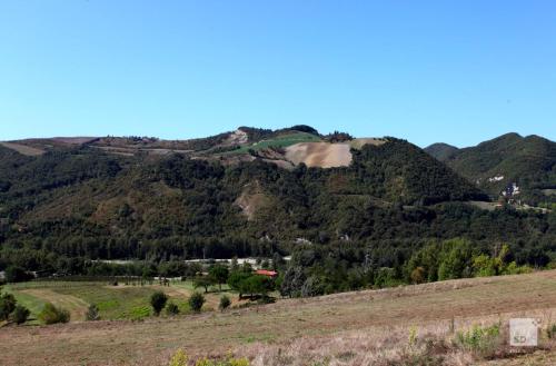 a view of a mountain with a house on it at Locanda Dei Cinque Cerri in Sasso Marconi