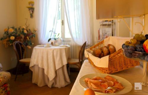a table with a bowl of fruit and a basket of bread at Locanda Dei Cinque Cerri in Sasso Marconi