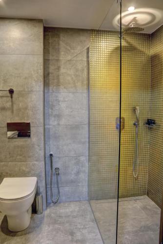 a bathroom with a toilet and a glass shower at Putney Hotel in London