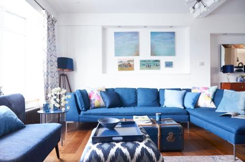 a living room with blue couches and a table at Bell Lodge in Chichester