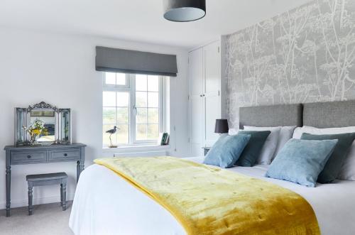 a bedroom with a large white bed with blue pillows at Bell Lodge in Chichester