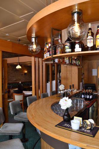 a bar in a restaurant with tables and chairs at Fletcher Hotel De Zalm in Brielle