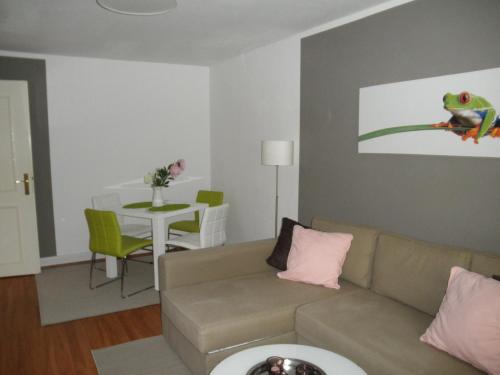 ein Wohnzimmer mit einem Sofa und einem Tisch in der Unterkunft Appartement Cécile in Potsdam