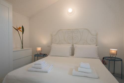 een slaapkamer met een wit bed en 2 handdoeken bij Sul Mare Sardegna Villa Eudora in Villasimius