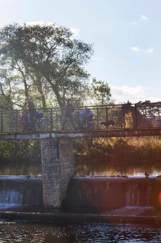 two people riding bikes on a bridge over a waterfall at The Corner House Hotel in Taunton
