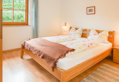 een slaapkamer met een groot bed met roze en gele kussens bij Weingut & Apartments Weitgruber Raffeis in Merano