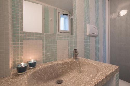 een badkamer met een wastafel met twee kaarsen erop bij Sul Mare Sardegna Villa Eunice in Villasimius