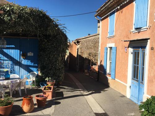 an alley with a blue door and some plants at 40 Rue du Ventoux in Bédoin