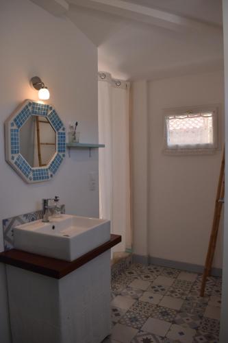 baño con lavabo y espejo en la pared en La villa tamaris maison à partager, en Vieux-Boucau-les-Bains