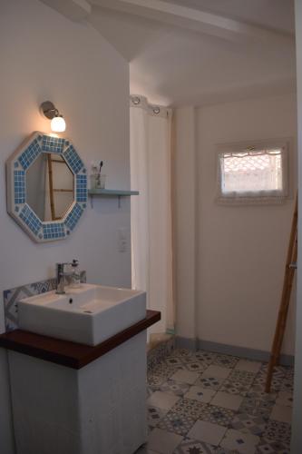 ein Badezimmer mit Waschbecken und Spiegel an der Wand in der Unterkunft La villa tamaris maison à partager in Vieux-Boucau-les-Bains