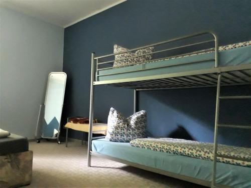 a bedroom with two bunk beds and a blue wall at Wohnung in Zarnewanz nahe Ostsee in Zarnewanz