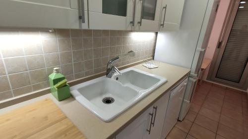 a kitchen with a sink and a green soap dispenser at Moderna Villa Cerca de la Playa Almadrava in L'Ametlla de Mar