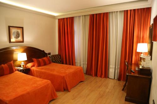 
a hotel room with two beds and two lamps at Princesa Ana in Granada
