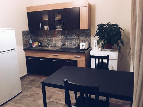 a kitchen with a black table and a white refrigerator at Studio in heart of Limassol in Limassol
