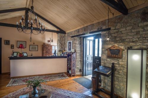 a living room with a stone wall and a chandelier at Princess Lanassa in Kostitsi