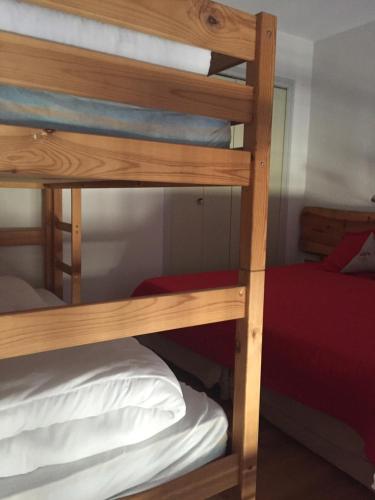 kilka łóżek piętrowych w pokoju z łóżkiem w obiekcie CHEZ LYLi & COMPAGNIE, PISCINE, JACCUZZI, SALLE DE SPORT w mieście Bolquere Pyrenees 2000