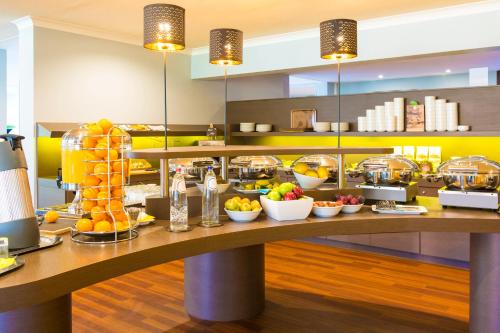a breakfast buffet in a hotel with fruit on a table at ibis Styles Louvain-la-Neuve Hotel and Events in Louvain-la-Neuve