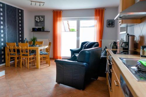 - une cuisine et une salle à manger avec une table et des chaises dans l'établissement Ferienhaus Strandperle, à Horumersiel
