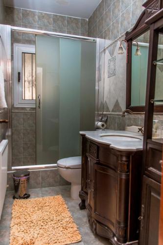 a bathroom with a sink and a toilet and a shower at 6 bdr villa with TENNIS COURT in Paphos