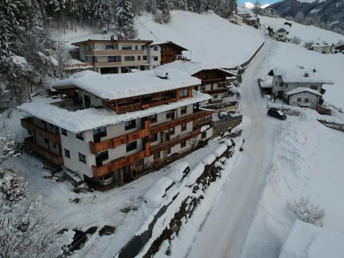 a building covered in snow on a snow covered road at Ferienwohnung Schiestl in Zell am Ziller