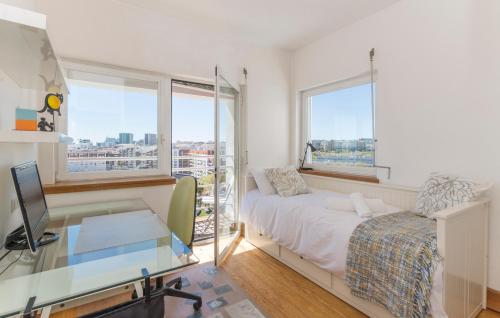 a bedroom with a bed and a desk and windows at Eco Apartment @ Torre Verde (Green Tower) in Lisbon