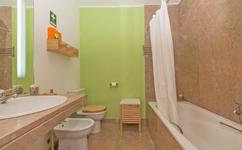 a bathroom with a sink and a toilet and a bath tub at Eco Apartment @ Torre Verde (Green Tower) in Lisbon